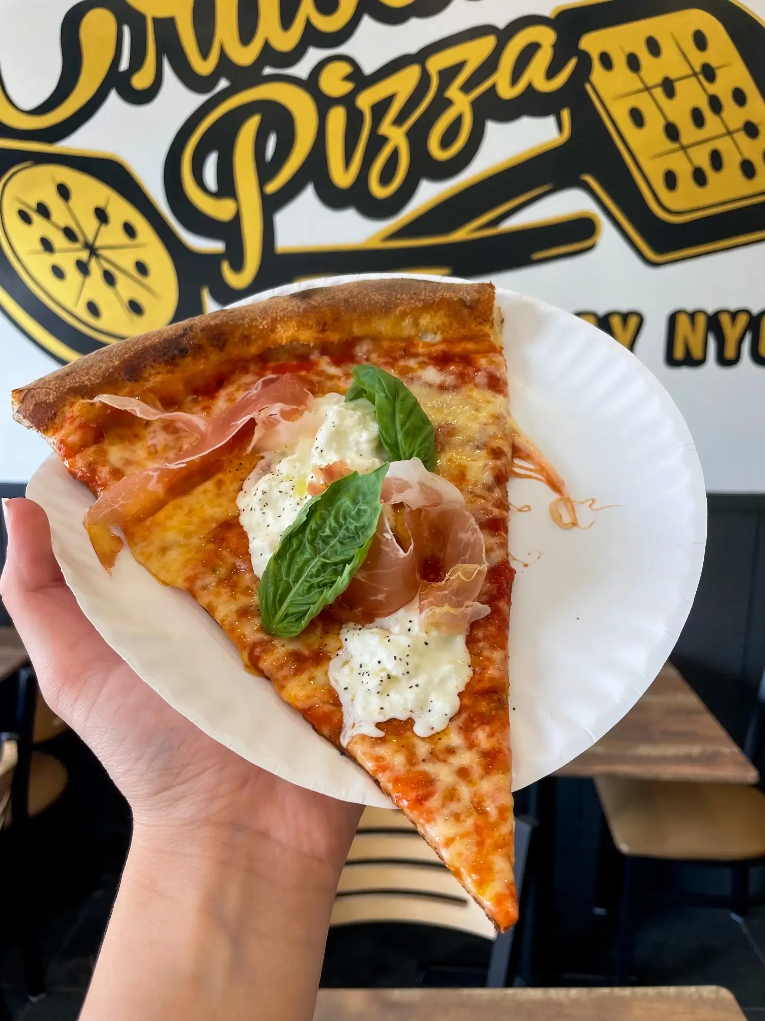 Authentic New York-style pizza slice from Crustinos Pizza, showcasing melted cheese and fresh toppings.